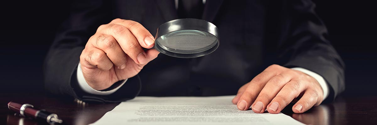 Closely examining a report using a magnifying glass