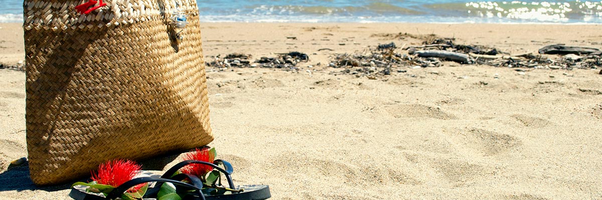Flax kete and jandals on the beach