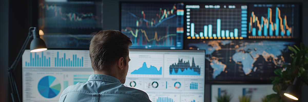 Fund manager working with an array of screens showing share values from around the world