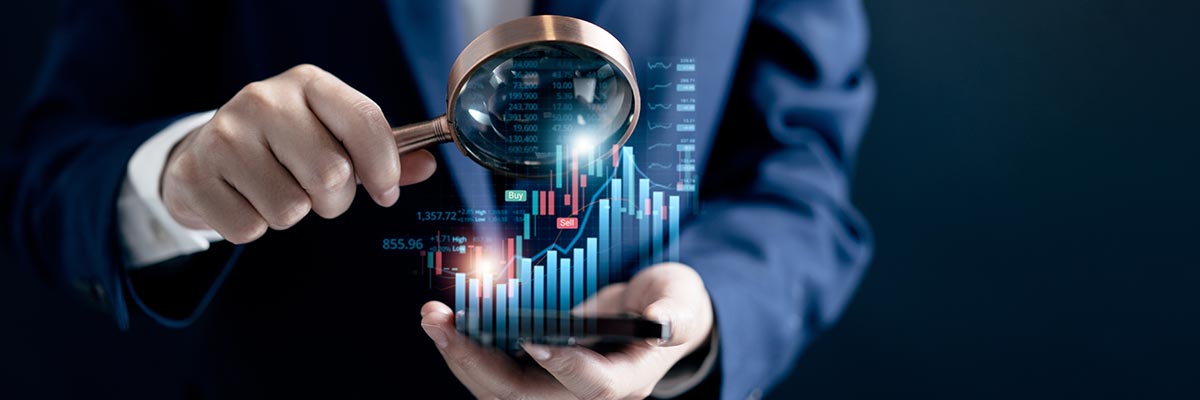 Man examining financial data through a magnifying glass