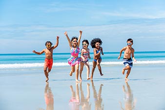 Happy kids running on the beach