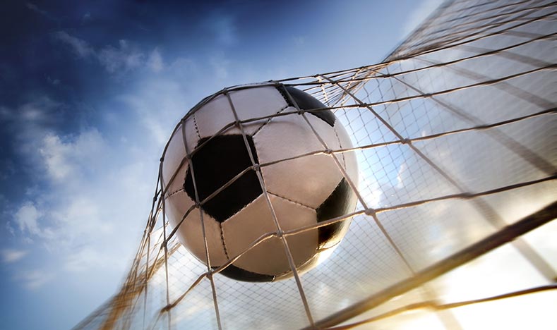 Football flying into the back of the net as a goal is scored