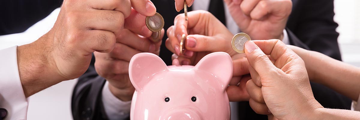 Many people putting coins into a piggy-bank