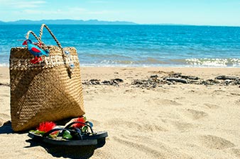 Flax kete and jandals on the beach