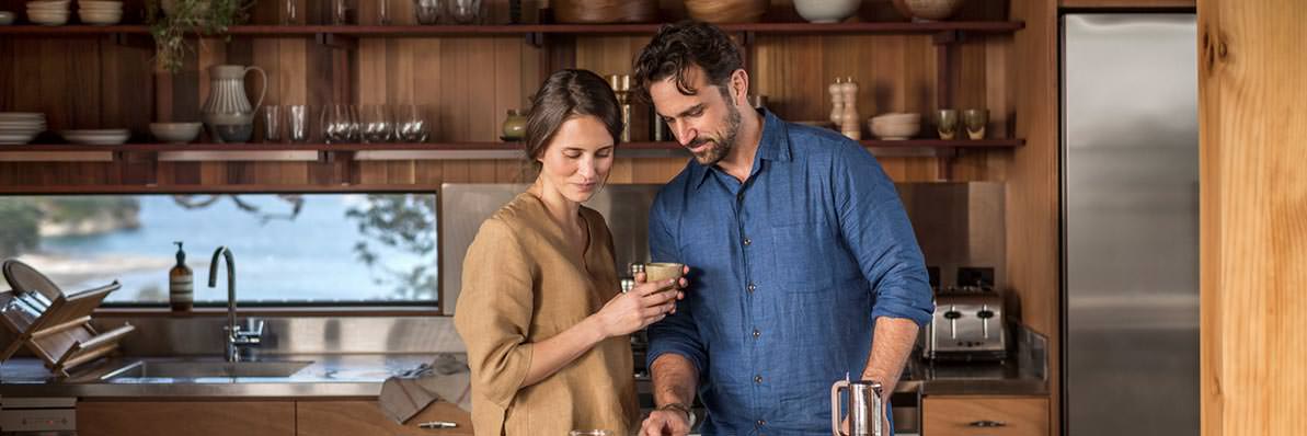 Couple standing together in the kitchen of their luxurious bach
